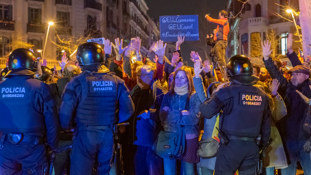 Police officers facing demonstrators at a street protest in Barcelona; illustrative image, not a photograph of the October 24 incident.
